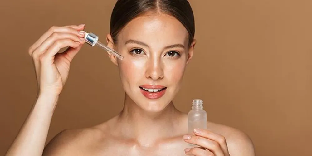 "Close-up of a dropper applying facial serum, illustrating the key serum uses for glowing and hydrated skin."